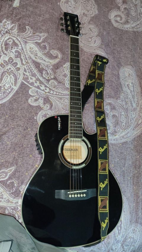 Freeman akustik-elektro gitara. Gitara qara rəngdədir və cutaway
