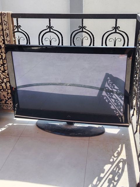 LCD televizor, qara korpus və oval dayaqlı model. - Təxminən 40–46