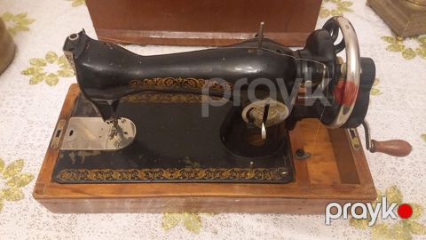 Antik üslubda mexaniki tikiş maşını. Əl ilə fırladılan yan qolu və