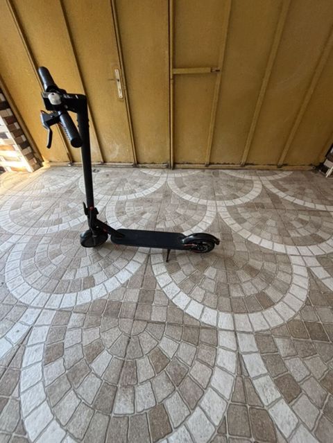 Qara rəngli elektrik skuter. Şəkildə yığcam və minimal dizayna malik