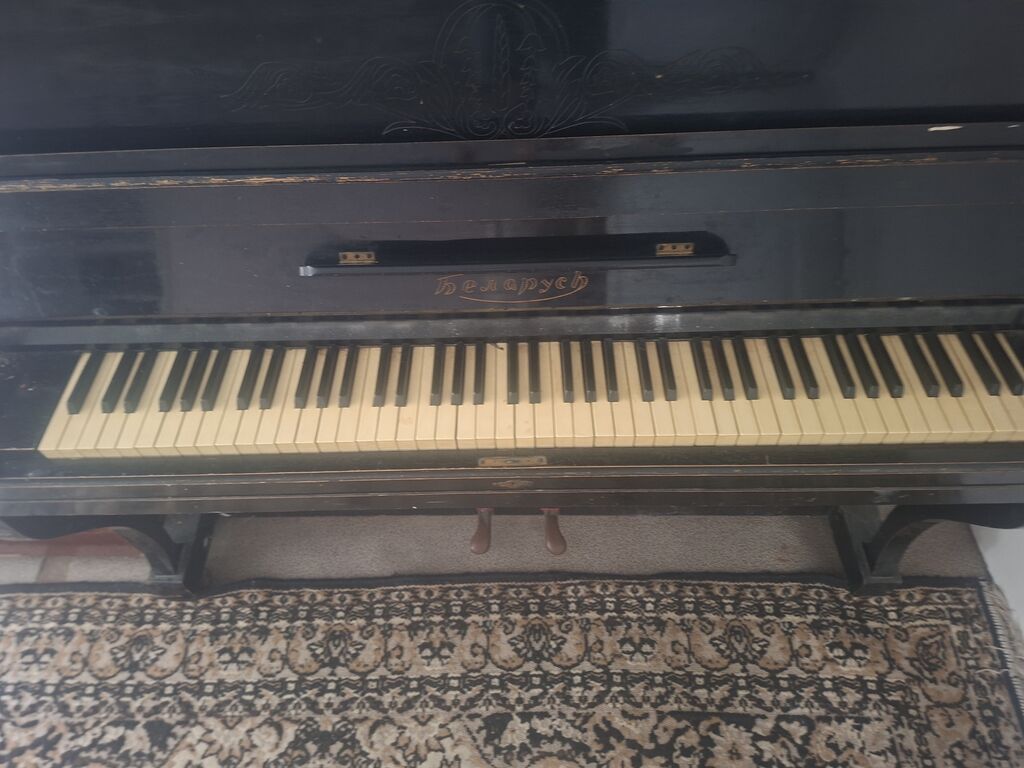 Qara rəngli, klassik üslubda akustik pianino. Korpus üzərində — Mallar, Digah