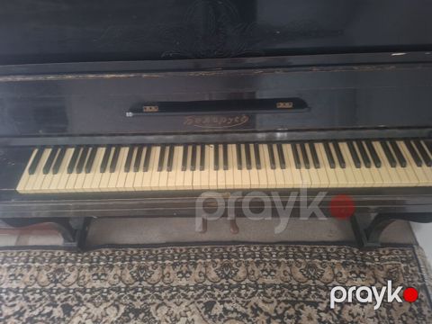 Qara rəngli, klassik üslubda akustik pianino. Korpus üzərində