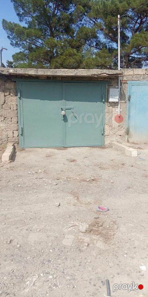 Metall qapılı, ikitərəfli açılan qaraj. İçəridə avtomobil üçün baxış