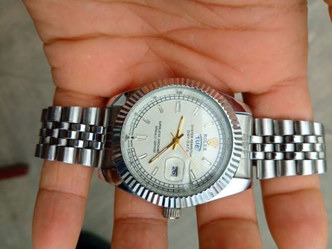 Saat: Rolex Oyster Perpetual Day‑Date stili, gümüşü tonlarda — Saray