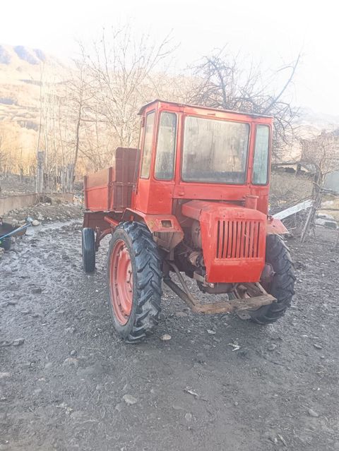 Qırmızı rəngli yığcam kənd təsərrüfatı traktoru, arxada yük daşımaq — Bakı