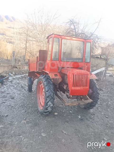 Qırmızı rəngli yığcam kənd təsərrüfatı traktoru, arxada yük daşımaq — Bakı