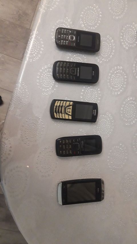 Şəkildə müxtəlif markalara aid 5 ədəd mobil telefon görünür. Modellər — Bakı