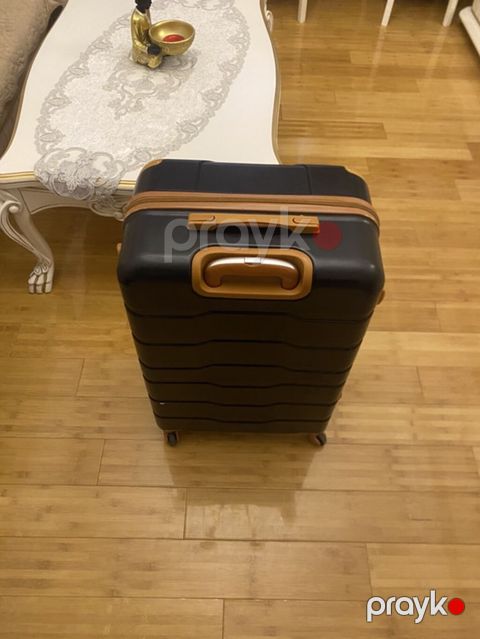 Qara rəngli, sərt korpuslu səyahət çamadanı. Dizaynında qəhvəyi