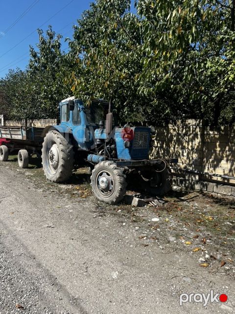 Mavi rəngli təkərli kənd təsərrüfatı traktoru və qoşqu — Quba