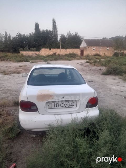 Ağ rəngli sedan avtomobil Xüsusiyyətlər: - Korpus: 4 qapılı sedan — Neftçala