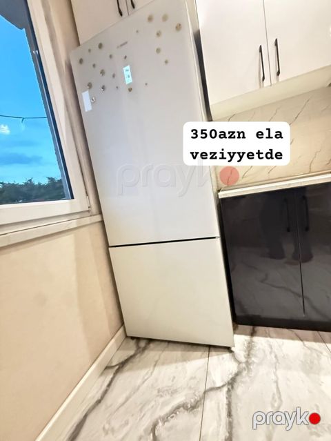 Ağ rəngli iki bölməli soyuducu. Yuxarıda soyuducu, aşağıda dondurucu — Bakı