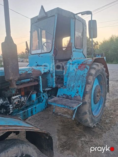 Mavi rəngli təkərli traktor - Kabinli konstruksiya, geniş ön və yan — Beyləqan