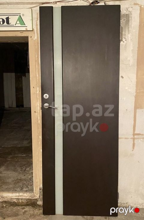 Qəhvəyi rəngdə, müasir dizaynlı daxili qapı. Qapının üzərində — Bakı