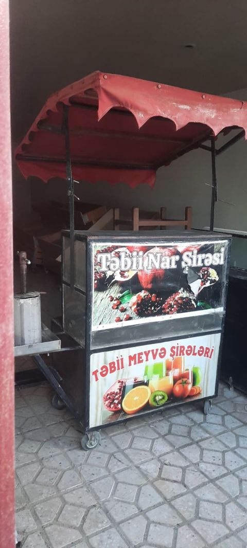 Təbii meyvə şirələri üçün səyyar satış arabası. Arabanın üzərində — Digah