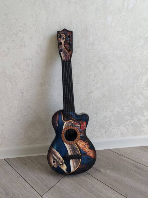 Dekorativ uşaq gitara formasında musiqi aləti. Korpus üzərində — Сумгайыт