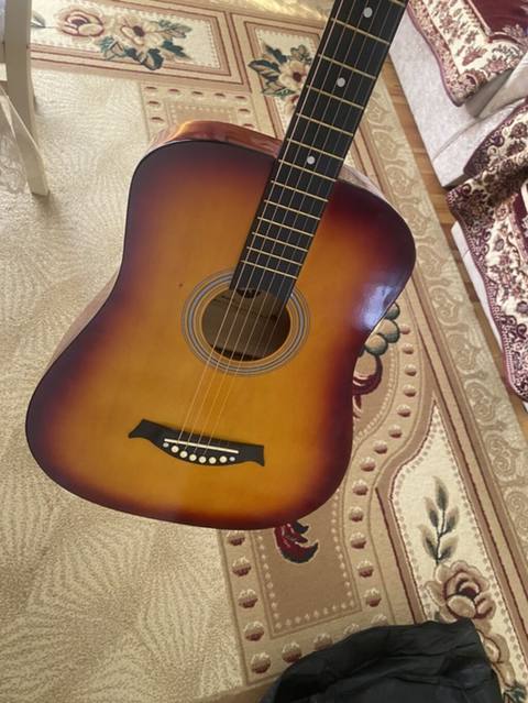 Üstündə çanta, divardan asılqan və simlər verilir Akkustik gitara — Sabirabad