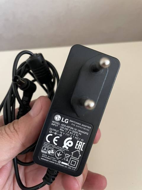 LG orijinal “Switching Adapter” enerji bloku LG televizorunun üstündə — Компьютерлер және ноутбуктер