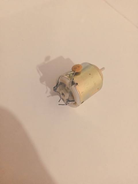 Kiçik ölçülü elektrik mühərriki (DC motor). Silindrik metal gövdəyə — Qubalı