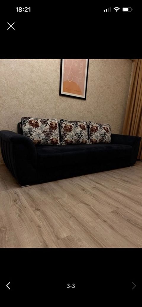 Qara rəngli yumşaq parça ilə üzlənmiş geniş divan. Korpus aşağı