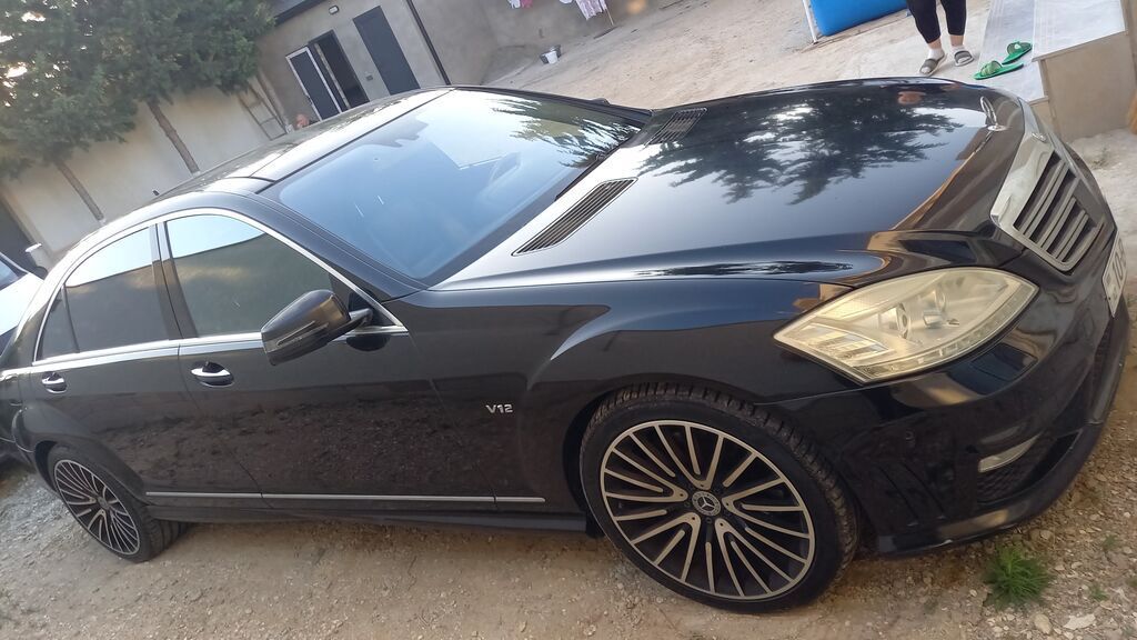 Mercedes‑Benz S-Class sedan (W221), qara rəng, V12 emblemli. Xarici