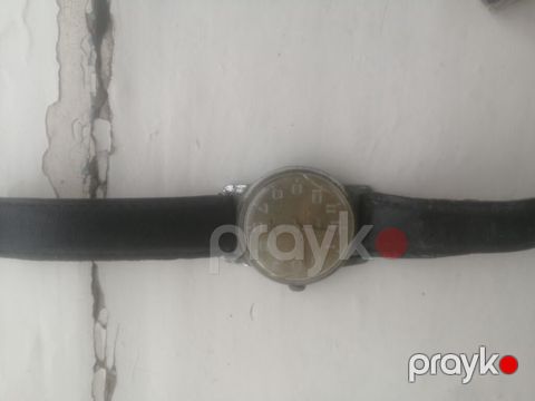 Qara qayışlı klassik qol saatı. Saat dairəvi formalı korpusa