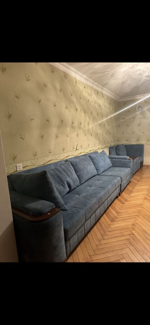 Mavi rəngli, yumşaq parça ilə üzlənmiş uzun divan dəsti. Dəst geniş