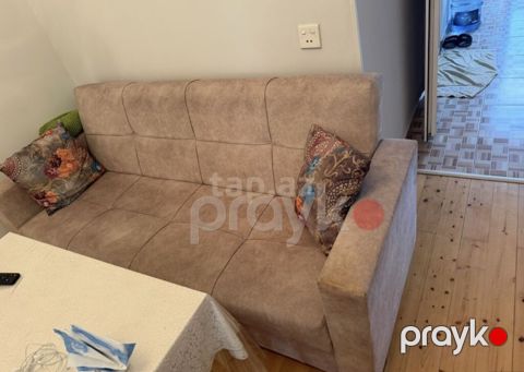 Bej rəngli, kompakt 3 nəfərlik divan. Yumşaq, toxumalı parça üzlük və