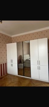 Ağ rəngdə geniş qarderob şkafı. - Dizayn: düz xətli, minimal üslub; — Mebel