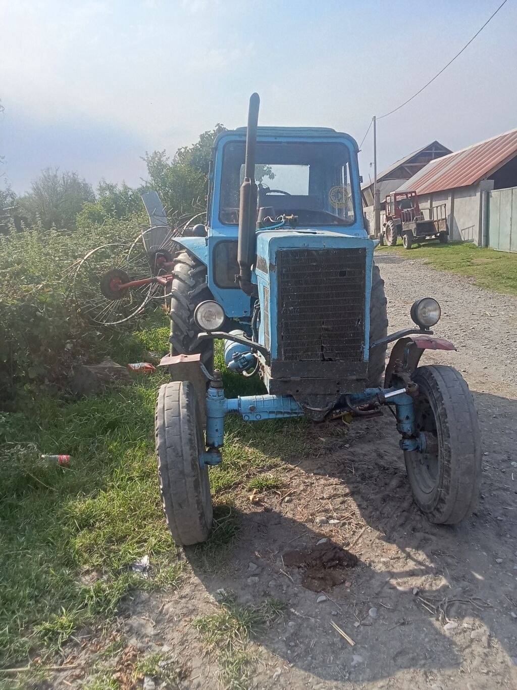 Mavi rəngli tək kabinəli təkərli traktor. Texniki xüsusiyyətlər və