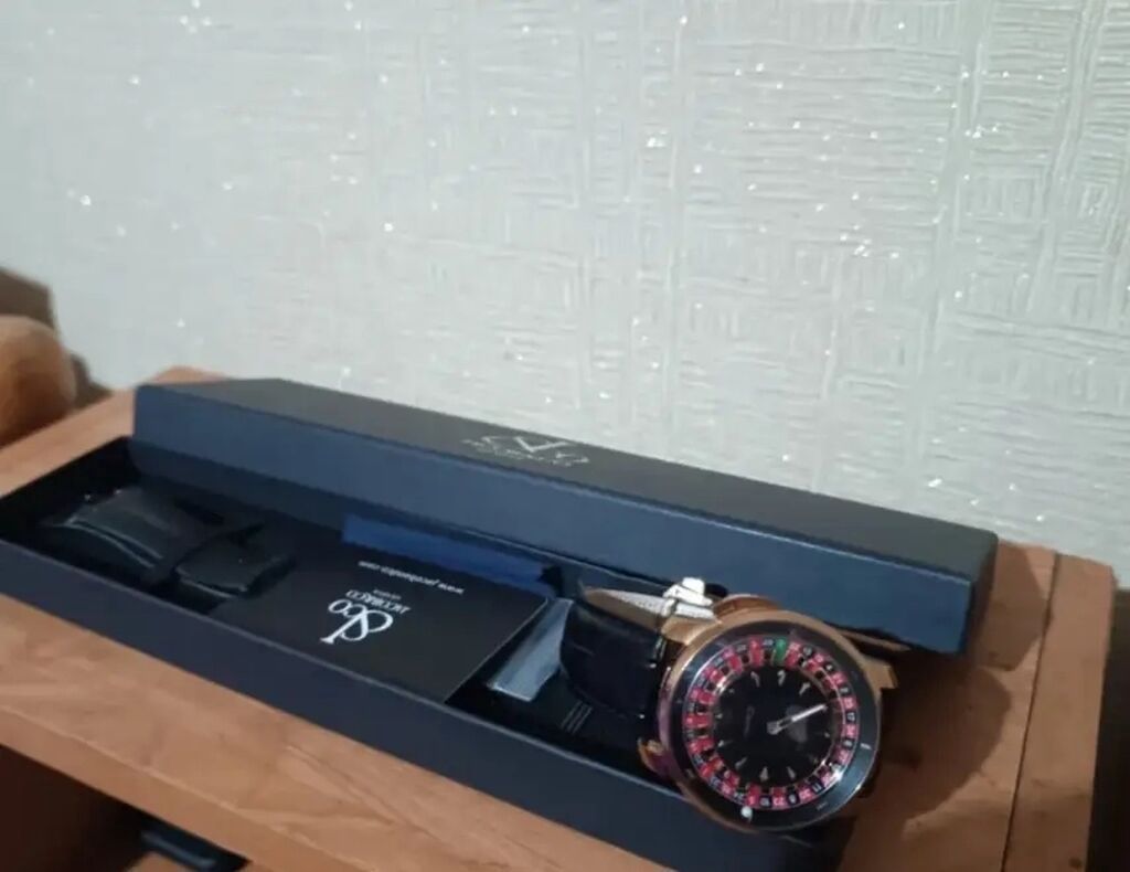 Qara qayışlı, iri siferblatlı qol saatı təqdim olunur. Saat qutusu və